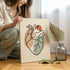 Person holding one line heart artwork in a light room