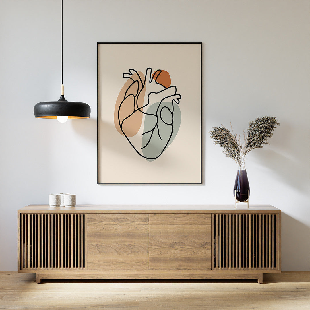Black framed one line heart art on a wall above a wooden cabinet