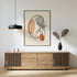 Minimalist kidney line art in a room above a sideboard.