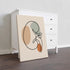 Minimalist kidney line art on stretched canvas beside a dresser.