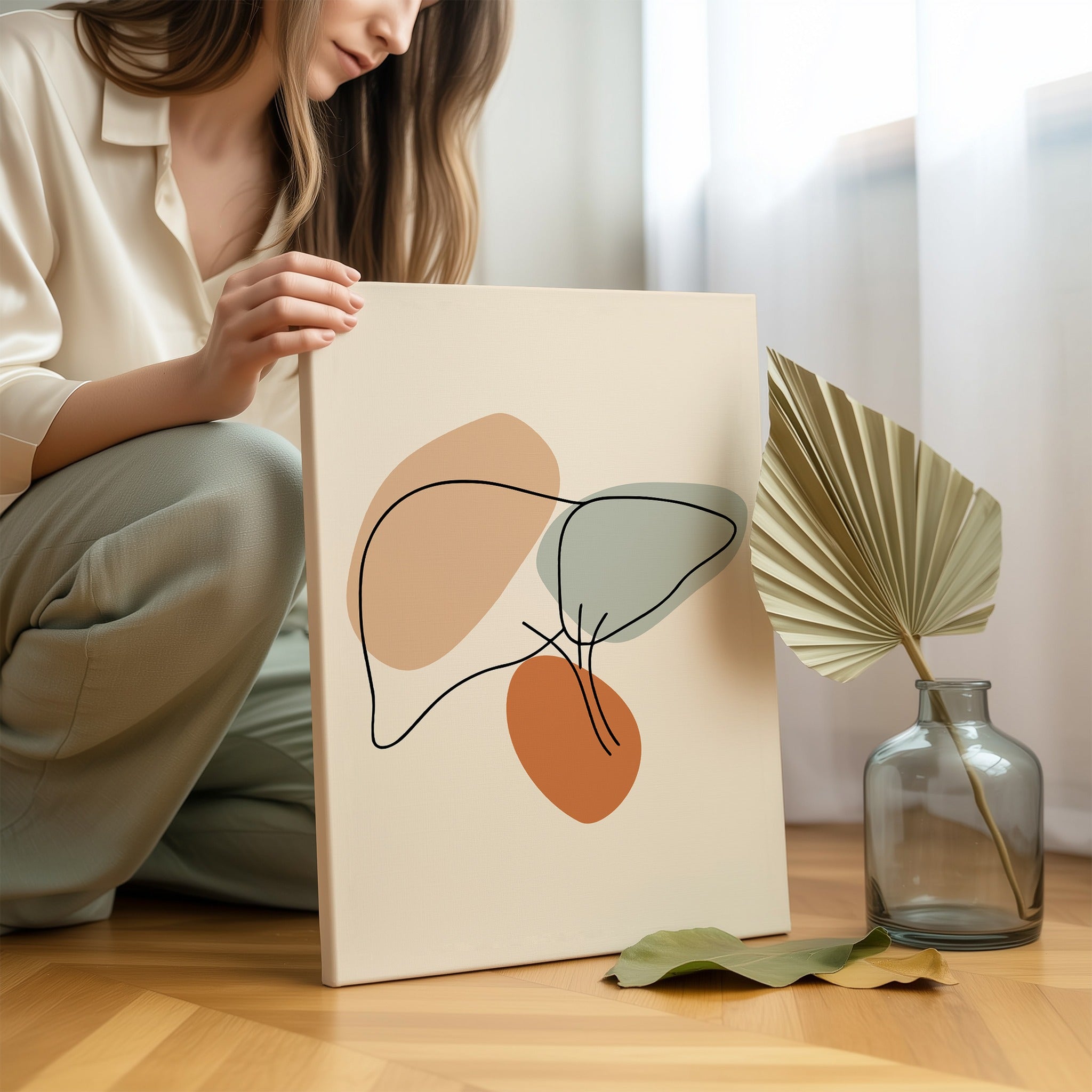 Minimalist liver line art held by a person in a bright neutral room.
