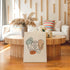 Pelvis anatomy canvas leaning in front of a round wooden coffee table in a bright living room.
