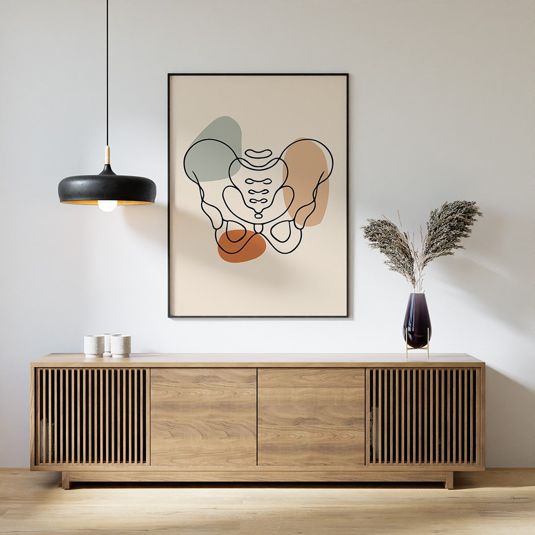 Black-framed pelvis line art displayed above a wooden sideboard with a pendant lamp and vase.