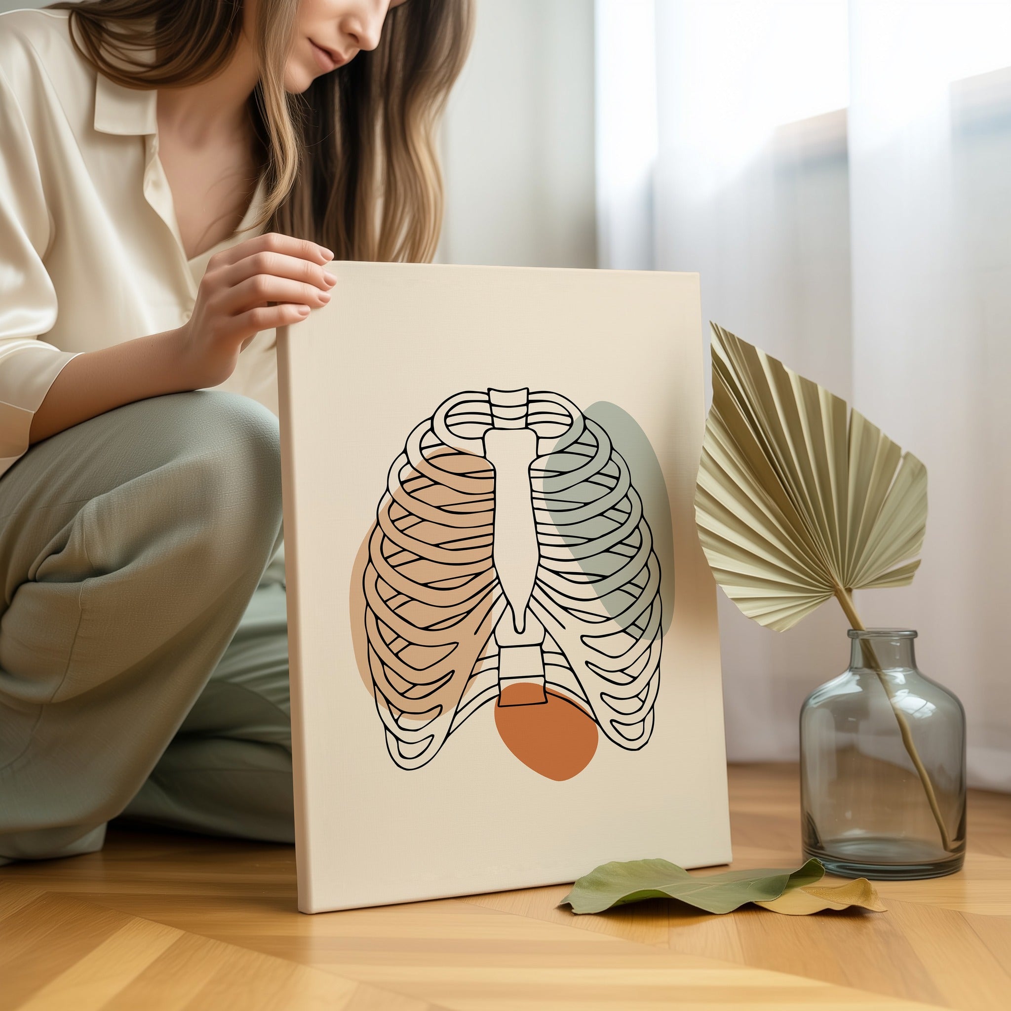 Minimalist rib cage line art held by a person in a bright neutral room.