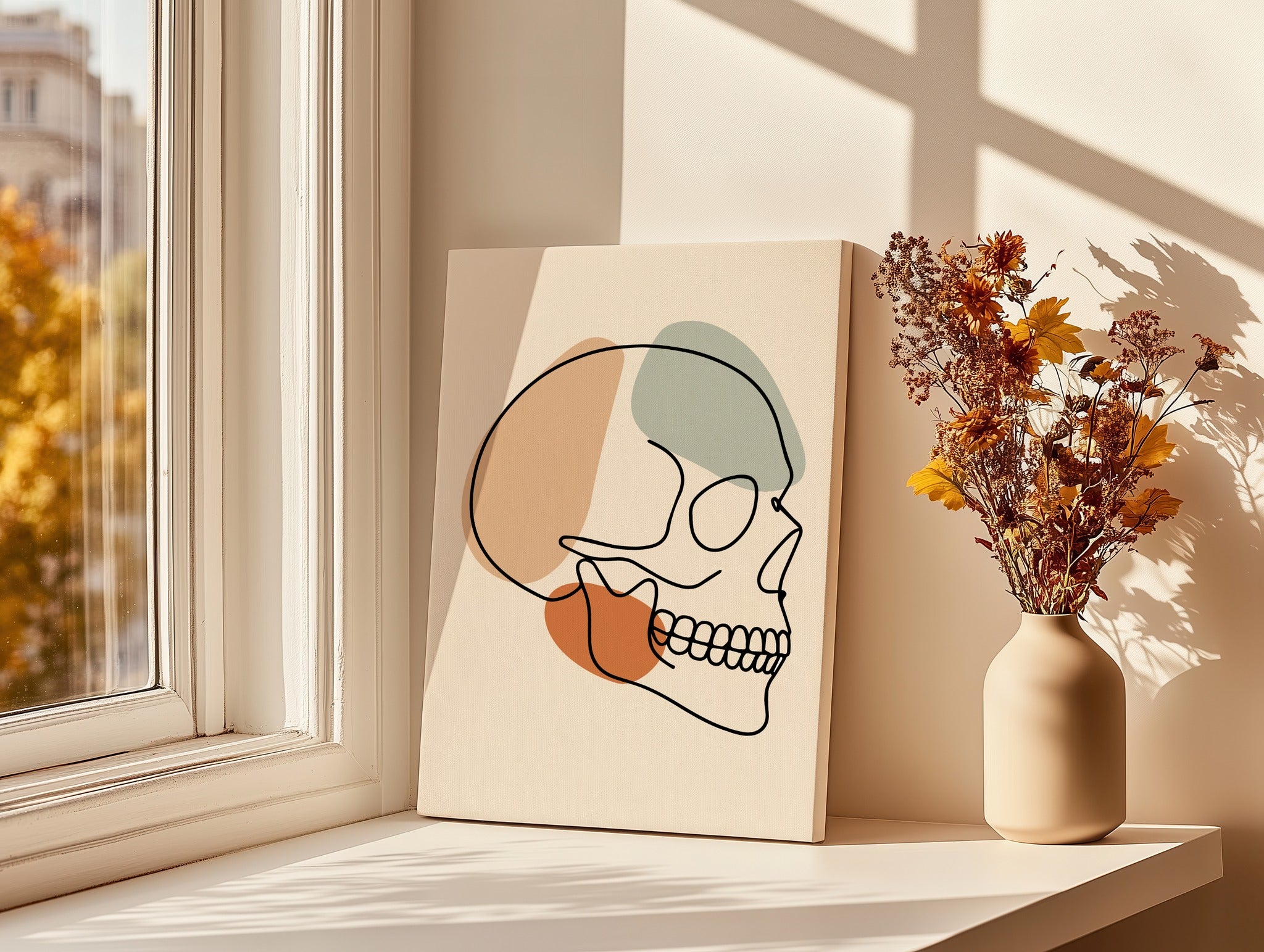 Minimalist skull line art displayed beside a bright window.