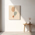 Minimalist spine canvas hanging above a small wooden table in a light neutral room.